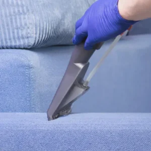 Close-up of professional upholstery cleaning, showcasing deep-cleaning of a blue sofa.